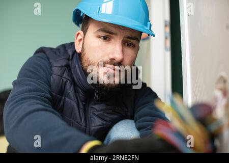 handsome electrician repairing electrical box Stock Photo