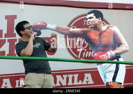(160610) -- QUEZON CITY, June 10, 2016 -- A man poses beside a life-size display of Muhammad Ali during an exhibit inside a mall in Quezon City, the Philippines, June 10, 2016. The exhibit showcased vintage photos, posters, and other memorabilia from the 1975, when Muhammad Ali versus Joe Frazier boxing fight dubbed Thrilla in Manila , to pay tribute to Ali who died in Phoenix, Arizona, at the age of 74 on June 3, 2016. ) (zjy) PHILIPPINES-QUEZON CITY-MUHAMMAD ALI-TRIBUTE EXHIBIT RouellexUmali PUBLICATIONxNOTxINxCHN   160610 Quezon City June 10 2016 a Man Poses Beside a Life Size Display of Mu Stock Photo