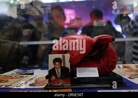 (160610) -- QUEZON CITY, June 10, 2016 -- People look at a pair of boxing gloves signed by Muhammad Ali that he wore in the Thrilla in Manila fight during an exhibit inside a mall in Quezon City, the Philippines, June 10, 2016. The exhibit showcased vintage photos, posters, and other memorabilia from the 1975, when Muhammad Ali versus Joe Frazier boxing fight dubbed Thrilla in Manila , to pay tribute to Ali who died in Phoenix, Arizona, at the age of 74 on June 3, 2016. ) (zjy) PHILIPPINES-QUEZON CITY-MUHAMMAD ALI-TRIBUTE EXHIBIT RouellexUmali PUBLICATIONxNOTxINxCHN   160610 Quezon City June 1 Stock Photo