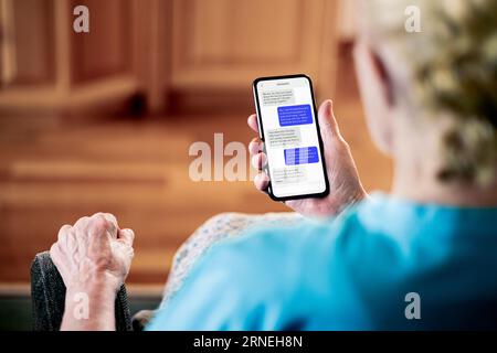 Text or chat messages in phone. Elder senior mature woman sms texting with friend or family. Old lady with cellphone messaging app. Stock Photo