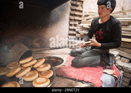 (160703) -- KASHGAR, July 3, 2016 -- A man takes baked nang, a kind of crusty pancake, staple food of the Kashgar people, out of a heated brick oven in Kashgar, northwest China s Xinjiang Uygur Autonomous Region, June 28, 2016. Bakers spent over 16 hours making around four or five thousand nangs to meet the needs as the breaking fast is approaching. Bu Duomen) (wyl) CHINA-XINJIANG-KASHGAR-NANG MAKER (CN) Buduomen PUBLICATIONxNOTxINxCHN   160703 Kashgar July 3 2016 a Man Takes BAKED Nang a Child of crusty Pancake Staple Food of The Kashgar Celebrities out of a Heated Brick OVEN in Kashgar North Stock Photo