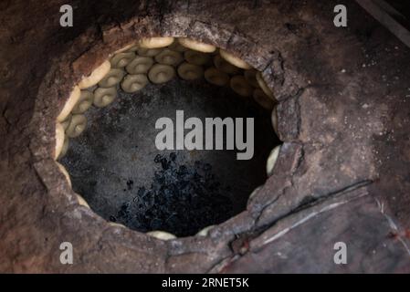 (160703) -- KASHGAR, July 2, 2016 -- Photo taken on July 2, 2016 shows nang, a kind of crusty pancake, staple food of the Kashgar people, sticking inside a heated brick oven in Kashgar, northwest China s Xinjiang Uygur Autonomous Region. Bakers spent over 16 hours making around four or five thousand nangs to meet the needs as the breaking fast is approaching. Bu Duomen) (wyl) CHINA-XINJIANG-KASHGAR-NANG MAKER (CN) Buduomen PUBLICATIONxNOTxINxCHN   160703 Kashgar July 2 2016 Photo Taken ON July 2 2016 Shows Nang a Child of crusty Pancake Staple Food of The Kashgar Celebrities sticking Inside a Stock Photo