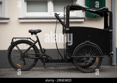 carrier cycle parking on street next to house waiting to get packed with heavy loads to be carried by cycler within city environmentally friendly Stock Photo