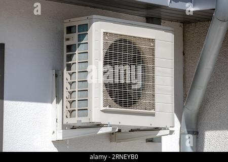 old aged air conditioner machine outside mounted at wall with dirty ventilator of cooler device Stock Photo