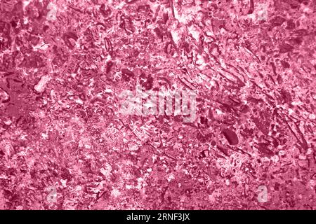 Background of polished stone texture with abstract pattern, for design, uneven surface, full frame. Copy space. Toned Pacific Pink. Selective focus. Stock Photo