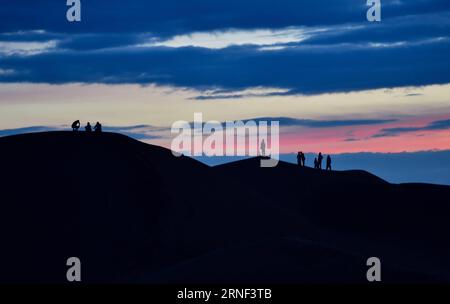 (160717) -- ORDOS, July 15, 2016 -- Silhouettes of tourists are seen on sand dunes at the Whistling Dune Bay in Dalad Qi in Ordos, north China s Inner Mongolia Autonomous Region, July 15, 2016. Located in the east of Kubuqi Desert, the Whistling Dune Bay was developed as a tourist destination since 1984. After years of improvement, it became a landmark for tourism industry of the Inner Mongolia Autonomous Region. ) (zhs) CHINA-INNER MONGOLIA-ORDOS-DESERT TOURISM (CN) LianxZhen PUBLICATIONxNOTxINxCHN   160717 Ordos July 15 2016 silhouettes of tourists are Lakes ON Sand Dunes AT The whistling Du Stock Photo