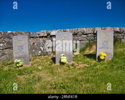 Three War Graves with flowers of unknown sailors of the merchant navy who lost their lives in the Second World War. Taken on a sunny day with a blue s Stock Photo