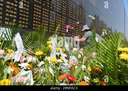 (160728) -- TANGSHAN, July 28, 2016 -- A woman pastes flowers beside the name of her relative killed in the 1976 Tangshan earthquake listed on a memorial wall in Tangshan, north China s Hebei Province, July 28, 2016. Local residents came to the Tangshan Earthquake Ruins Memorial Park on Thursday to mark the 40th anniversary of the devastating earthquake that killed their family members and friends. )(wsw) CHINA-HEBEI-TANGSHAN-EARTHQUAKE-COMMEMORATION (CN) MouxYu PUBLICATIONxNOTxINxCHN   160728 Tang Shan July 28 2016 a Woman pastes Flowers Beside The Name of her relative KILLED in The 1976 Tang Stock Photo