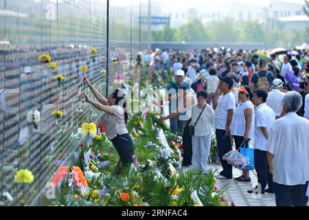 (160728) -- TANGSHAN, July 28, 2016 -- A woman pastes a flower beside the name of her relative killed in the 1976 Tangshan earthquake listed on a memorial wall in Tangshan, north China s Hebei Province, July 28, 2016. Local residents came to the Tangshan Earthquake Ruins Memorial Park on Thursday to mark the 40th anniversary of the devastating earthquake that killed their family members and friends. )(wsw) CHINA-HEBEI-TANGSHAN-EARTHQUAKE-COMMEMORATION (CN) MouxYu PUBLICATIONxNOTxINxCHN   160728 Tang Shan July 28 2016 a Woman pastes a Flower Beside The Name of her relative KILLED in The 1976 Ta Stock Photo