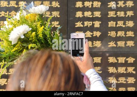 (160728) -- TANGSHAN, July 28, 2016 -- A woman takes photos of the name of her relative killed in the 1976 Tangshan earthquake in front of a memorial wall in Tangshan, north China s Hebei Province, July 28, 2016. Local residents came to the Tangshan Earthquake Ruins Memorial Park on Thursday to mark the 40th anniversary of the devastating earthquake that killed their family members and friends. )(wsw) CHINA-HEBEI-TANGSHAN-EARTHQUAKE-COMMEMORATION (CN) MouxYu PUBLICATIONxNOTxINxCHN   160728 Tang Shan July 28 2016 a Woman Takes Photos of The Name of her relative KILLED in The 1976 Tang Shan Eart Stock Photo