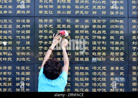 (160728) -- TANGSHAN, July 28, 2016 -- A woman pastes flowers beside the name of her relative killed in the 1976 Tangshan earthquake listed on a memorial wall in Tangshan, north China s Hebei Province, July 28, 2016. Local residents came to the Tangshan Earthquake Ruins Memorial Park on Thursday to mark the 40th anniversary of the devastating earthquake that killed their family members and friends. )(wsw) CHINA-HEBEI-TANGSHAN-EARTHQUAKE-COMMEMORATION (CN) MouxYu PUBLICATIONxNOTxINxCHN   160728 Tang Shan July 28 2016 a Woman pastes Flowers Beside The Name of her relative KILLED in The 1976 Tang Stock Photo