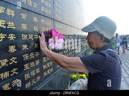 (160728) -- TANGSHAN, July 28, 2016 -- A woman pastes paper flowers beside the name of her relative killed in the 1976 Tangshan earthquake listed on a memorial wall in Tangshan, north China s Hebei Province, July 28, 2016. Local residents came to the Tangshan Earthquake Ruins Memorial Park on Thursday to mark the 40th anniversary of the devastating earthquake that killed their family members and friends. )(wsw) CHINA-HEBEI-TANGSHAN-EARTHQUAKE-COMMEMORATION (CN) MouxYu PUBLICATIONxNOTxINxCHN   160728 Tang Shan July 28 2016 a Woman pastes Paper Flowers Beside The Name of her relative KILLED in T Stock Photo