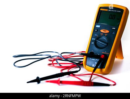 Digital multimeter with probes and green backlit display isolated on a white background Stock Photo