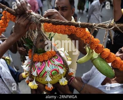 (160825) -- MUMBAI, Aug. 25, 2016 -- Residents of Dadar neighborhood tie the clay curd pot to be broken to a rope during the celebration of Dahi Handi festival in Mumbai, India, Aug. 25, 2016. Dahi Handi is an Indian festival to mark the birth of Hindu god Lord Krishna. Based on the legend of the child god Krishna stealing butter, the festival involves making a human pyramid and breaking an earthen pot filled with curd tied at height.)(cl) INDIA-MUMBAI-DAHI HANDI FESTIVAL-CELEBRATION BixXiaoyang PUBLICATIONxNOTxINxCHN   160825 Mumbai Aug 25 2016 Residents of DADAR Neighborhood Tie The Clay Cur Stock Photo