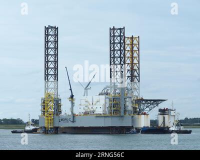 Oil drilling platform in the port of Vlissingen, Zeeland, the Netherlands, with two tug boats. Stock Photo