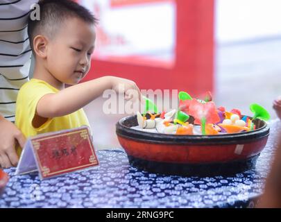 (160915) -- HANGZHOU, Sept. 15, 2016 -- A boy touches the rice flour sculpture during the Mid-Autumn Festival in Tangqi ancient town of Hangzhou, east China s Zhejiang Province, Sept. 15, 2016. It is a folk custom for local people to greet the Mid-Autumn Festival by making rice flour sculptures. ) (zhs) CHINA-HANGZHOU-MID-AUTUMN FESTIVAL-CUSTOM (CN) XuxYu PUBLICATIONxNOTxINxCHN   160915 Hangzhou Sept 15 2016 a Boy touches The Rice Flour Sculpture during The Mid Autumn Festival in Tangqi Ancient Town of Hangzhou East China S Zhejiang Province Sept 15 2016 IT IS a Folk Custom for Local Celebriti Stock Photo