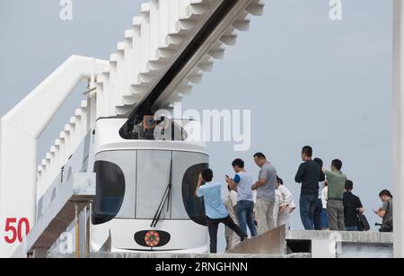 Schwebebahn in Chengdu, China (160930) -- CHENGDU, Sept. 30, 2016 -- People take photos of a lithium-battery powered train which is suspended from a railway line in Chengdu, southwest China s Sichuan Province, Sept. 30, 2016. China s first suspension railway line finished its test run Friday. The train, which has a speed of 60 km per hour, successfully ran along the 300-meter test section of the railway line after being suspended from the line.) (mp) CHINA-CHENGDU-SUSPENSION RAILWAY-TEST RUN (CN) JiangxHongjing PUBLICATIONxNOTxINxCHN   Levitation train in Chengdu China  Chengdu Sept 30 2016 Ce Stock Photo