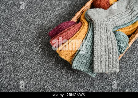 Hand-knitted woolen socks of different colors on grey background, top view Stock Photo
