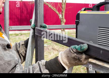 a man tries on a profile pipe for welding a metal frame. Stock Photo