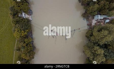 Aerial drone view of collapsed rope bridge close to Medno in Ljubljana, after heavy floods hit slovenia in the summer of 2023. Destroyed bridge over S Stock Photo