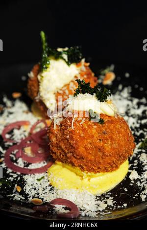 Arancini balls served in Valletta, Malta. They are one of the many popular dishes in Malta influenced by Italian, and specifically Sicilian, cuisine. Stock Photo