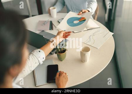 Close up of business colleagues analysts working with documents together sitting in office Stock Photo