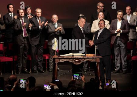 Kolumbien schließt neues Abkommen mit FARC-Guerilla (161124) -- BOGOTA, Nov. 24, 2016 -- Colombian President Juan Manuel Santos (L, front) and the leader of the Revolutionary Armed Forces of Colombia (FARC), Rodrigo Londono (R, front), shake hands during the signing ceremony of a revised peace agreement between the Colombian government and FARC at Colon Theater in Bogota, capital of Colombia, on Nov. 24, 2016. Juan Manuel Santos and Rodrigo Londono signed a revised peace agreement here on Thursday. This revised agreement will be sent to Congress. ) COLOMBIA-BOGOTA-GOVERNMENT-FARC-REVISED PEACE Stock Photo