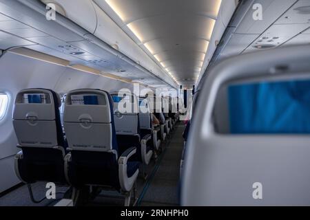 Interior of an airplane cabine with empty seats in a row. Stock Photo