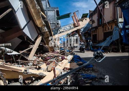 (161208) -- ACEH, Dec. 8, 2016 -- People pass a collapsed building at Meureudu market in Pidie Jaya district in Aceh, Indonesia, Dec. 8, 2016. Rescuers on early Thursday resumed the search for survivors in a powerful earthquake that hit the western Indonesian province of Aceh, killing at least 97 people. ) (zjy) INDONESIA-ACEH-EARTHQUAKE-AFTERMATH VerixSanovri PUBLICATIONxNOTxINxCHN   Aceh DEC 8 2016 Celebrities Passport a Collapsed Building AT  Market in  Jaya District in Aceh Indonesia DEC 8 2016 Rescue ON Early Thursday resumed The Search for Survivors in a Powerful Earthquake Thatcher Hit Stock Photo