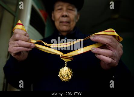 (161211) -- NANJING, Dec. 11, 2016 -- Li Gaoshan demonstrates a medal commemorating the 70th anniversary of the victory of the Chinese People s War of Resistance against Japanese Aggression, Nov. 21, 2016. Li Gaoshan, born in 1925 in south China s Guangdong Province, attended the battle of Nanjing in 1937 when he was 13 years old. He escaped from death after being arrested by Japanese troops. Japanese troops occupied eastern China s Nanjing on Dec. 13, 1937, and began a six-week massacre. Chinese records show more than 300,000 people -- not only disarmed soldiers but also civilians -- were bru Stock Photo
