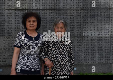 (161211) -- NANJING, Dec. 11, 2016 -- Ma Xiuying (R) and her daughter-in-law pose for photos in front of the wailing wall at the Memorial Hall of the Victims in Nanjing Massacre by Japanese Invaders in Nanjing, east China s Jiangsu Province, June 17, 2016. Ma Xiuying, born in 1922, survived by escaping to a refugee zone with her mother during the invasion of Japanese troops in 1937. Japanese troops occupied eastern China s Nanjing on Dec. 13, 1937, and began a six-week massacre. Chinese records show more than 300,000 people -- not only disarmed soldiers but also civilians -- were brutally murd Stock Photo