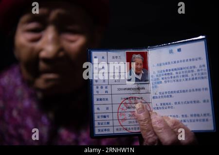 (161211) -- NANJING, Dec. 11, 2016 -- Yi Cuilan demonstrates a certificate of survivors of the Nanjing Massacre, Nov. 25, 2016. Yi Cuilan, born on May 6, 1923, survived from the invasion of Japanese troops by pretending to be a boy, seeking asylum from different refugee camps. Although she escaped from death, she suffered from severe pains all these years due to the brutal assault by Japanese invaders. Japanese troops occupied eastern China s Nanjing on Dec. 13, 1937, and began a six-week massacre. Chinese records show more than 300,000 people -- not only disarmed soldiers but also civilians - Stock Photo