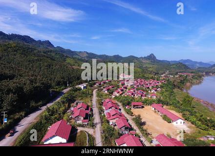(161214) -- LUANG PRABANG, Dec. 14, 2016 -- Photo taken on Dec. 12, 2016 shows the Hake migrant village in Luang Prabang province, northern Laos. The Hake migrant village was built in July 2014 next to the dam site of the first stage s No. 2 plant. At Hake, as many as 242 households have moved to new villa-style brick houses. After running southward through mountains and forests, Nam Ou River pours into the Mekong River in Laos northern Luang Prabang province, some 220 km north of the capital Vientiane. Thanks to the development of a full basin cascade hydropower project by a Chinese enterpris Stock Photo