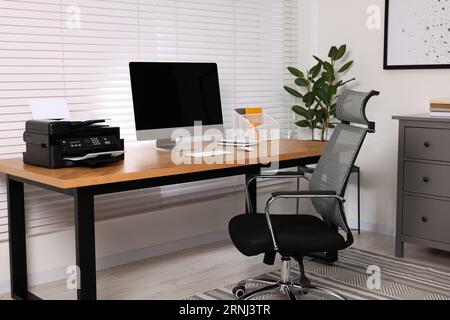 Stylish room interior with desk, modern printer and computer Stock Photo