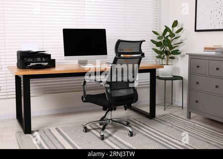 Stylish room interior with desk, modern printer and computer Stock Photo