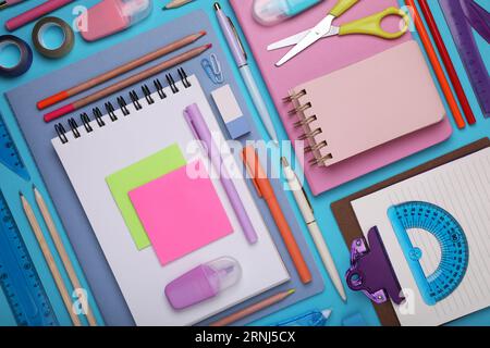 Flat lay composition with notebooks and other school stationery on light blue background. Back to school Stock Photo