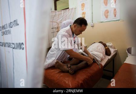 (170120) -- BEIJING, Jan. 20, 2017 -- A doctor of China s medical aid team operates acupuncture threament on a local patient in Tanzania s Zanziba, July 15, 2016. Chinese President Xi Jinping presented a bronze acupuncture statue on Jan. 18, 2017 to the World Health Organization (WHO) in Geneva, Switzerland, which shows acupuncture points on the human body. According to the WHO, 103 members have given approval to the practice of acupuncture and moxibustion, with 29 having enacted special statutes on traditional medicine, and 18 having included acupuncture and moxibustion treatment in their med Stock Photo