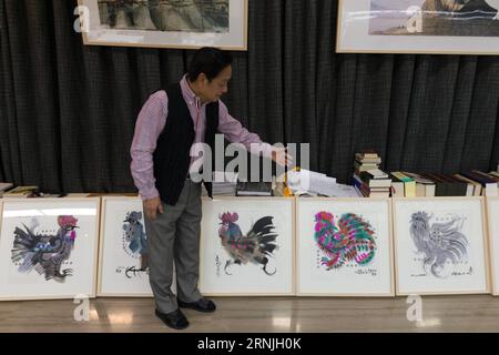(170126) -- BEIJING, Jan. 26, 2017 -- Chinese artist Han Meilin, 80, shows his paintings of roosters and hens at his studio in eastern district of Tongzhou in Beijing, capital of China, Jan. 24, 2017. Han, designer of the 2008 Beijing Olympic Games mascot Fuwa, has just finished the design of Chinese zodiac stamps for the upcoming Year of the Rooster. The set of Chinese Lunar New Year rooster stamps, issued earlier this month, contain two items showing a rooster striding proudly and a hen looking after her two chicks. Han applied rich color and elements of traditional Chinese painting to depic Stock Photo
