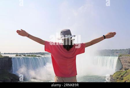 Teenager girl enjoying the panoramic view of Niagara Falls in summer, Canada Stock Photo