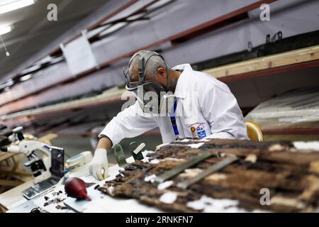 (170329) -- GIZA, March 29, 2017 -- An archaeologist works on parts of the second solar boat of Pharaoh Khufu at the restoration laboratory located in Giza, Egypt on March 29, 2017. Egypt opened its largest on-site antiquities laboratory to restore Pharaoh Khufu s second solar boat. King Khufu was a famous fourth dynasty Pharaoh who built the great Khufu Pyramid. His solar boat was designed to ferry him to the afterlife according to ancient Egyptian beliefs. The second solar boat of King Khufu was detected in 1987 in a large pit to the west of the first solar boat. Both boats lie on the southe Stock Photo