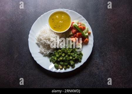 Healthy Indian vegetable thali of rice, boiled vegetables, salad and dal. Stock Photo