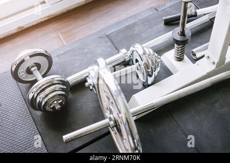 Metal dumbbell barbells on the floor, weight lifting body building equipments for healthy fitness gym Stock Photo