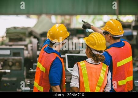 Engineer worker woman with male team working together Auditor in factory looking at Laptop computer happy smile. Stock Photo
