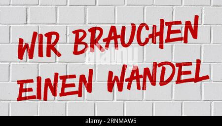 Graffiti on a brick wall - We need a change in german Stock Photo