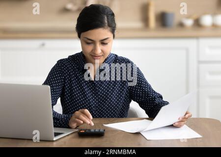 Positive focused freelance accountant woman working at home Stock Photo