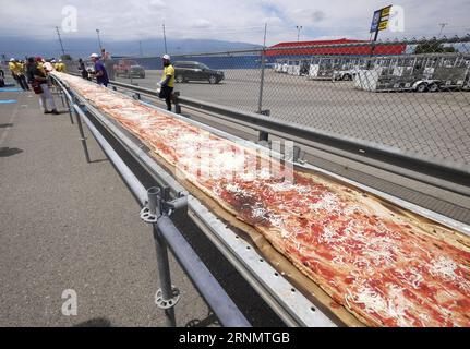 (170611) -- LOS ANGELES, June 11, 2017 -- Volunteers work on a pizza as they broke the Guinness World Records title for the longest pizza with a length of 1.32 miles (2.13 kilometers) in Fontana, the United Staes, June 10, 2017. The last longest pizza measured 1,853.88 meters and was achieved by Napoli Pizza Village, in Naples, Italy, May 18, 2016. ) (gj) U.S.-LOS ANGELES-LONGEST PIZZA ZhaoxHanrong PUBLICATIONxNOTxINxCHN   170611 Los Angeles June 11 2017 Volunteers Work ON a Pizza As They Broke The Guinness World Records Title for The LONGEST Pizza With a length of 1 32 Miles 2 13 Kilometers i Stock Photo