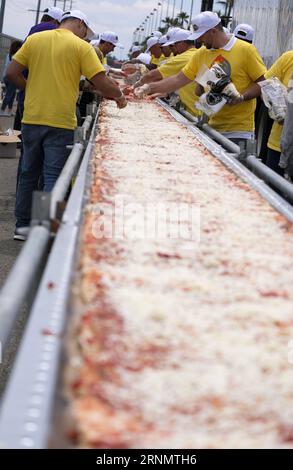 (170611) -- LOS ANGELES, June 11, 2017 -- Volunteers work on a pizza as they broke the Guinness World Records title for the longest pizza with a length of 1.32 miles (2.13 kilometers) in Fontana, the United Staes, June 10, 2017. The last longest pizza measured 1,853.88 meters and was achieved by Napoli Pizza Village, in Naples, Italy, May 18, 2016. ) (gj) U.S.-LOS ANGELES-LONGEST PIZZA ZhaoxHanrong PUBLICATIONxNOTxINxCHN   170611 Los Angeles June 11 2017 Volunteers Work ON a Pizza As They Broke The Guinness World Records Title for The LONGEST Pizza With a length of 1 32 Miles 2 13 Kilometers i Stock Photo