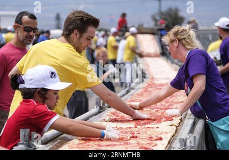 (170611) -- LOS ANGELES, June 11, 2017 -- Volunteers work on a pizza as they broke the Guinness World Records title for the longest pizza with a length of 1.32 miles (2.13 kilometers) in Fontana, the United Staes, June 10, 2017. The last longest pizza measured 1,853.88 meters and was achieved by Napoli Pizza Village, in Naples, Italy, May 18, 2016. ) (gj) U.S.-LOS ANGELES-LONGEST PIZZA ZhaoxHanrong PUBLICATIONxNOTxINxCHN   170611 Los Angeles June 11 2017 Volunteers Work ON a Pizza As They Broke The Guinness World Records Title for The LONGEST Pizza With a length of 1 32 Miles 2 13 Kilometers i Stock Photo