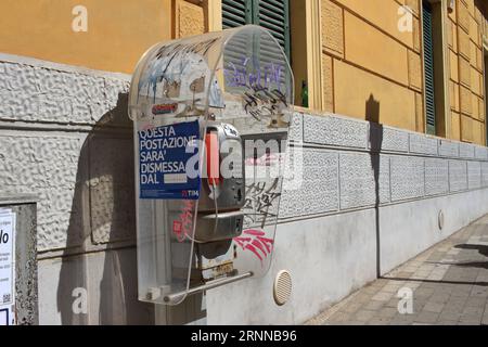 An old public phone works with coins and phone cards in the streets of the historic center. By the end of 2023, the Italian TIM will remove them . Stock Photo