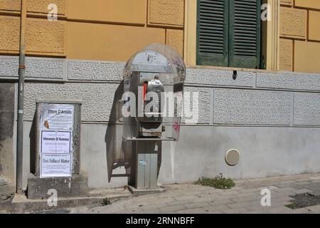 An old public phone works with coins and phone cards in the streets of the historic center. By the end of 2023, the Italian TIM will remove them . Stock Photo